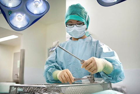 An operating department pracittioner looking at medical instruments