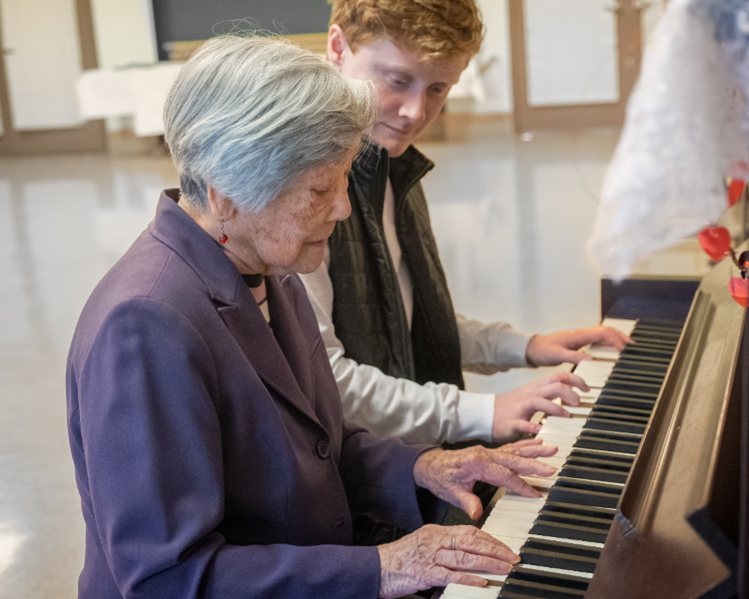 a patient and a music therapist playing the piano together