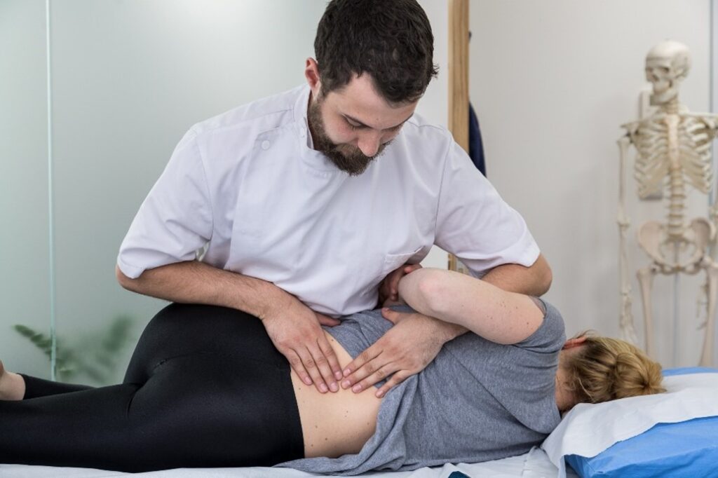 osteopath assessing a patient's back